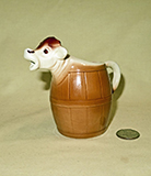 Goebel cow head sticking out of a barrel cow creamer