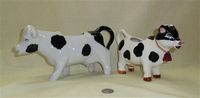 Two black and white cow creamers