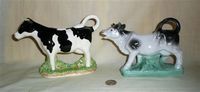Jamess Herriot black and white cow creamer, and one on a base with a stand under the belly