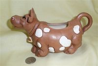 Brown cow caricature creamer with white spots
