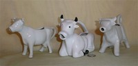 Three white cow creamers