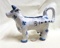 Heavy clay US folk art cow creamer, left