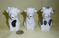 Three similar small white sitting cow cramers from Dansk, Spain and UK
