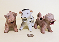 Two unglazed brown curly tailed Japanese cow creamers with white version