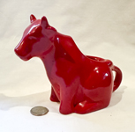 Plain red sitting up cow creamer