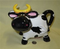 Black & white cow pitcher with big nose and yellow horns