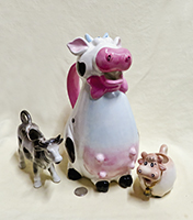 Three cow creamers of different sizes