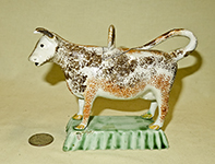 orange and brown sponged prattware cow on light green base, incised lid tith hoop, side