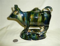 Green glazed cow creamer, left