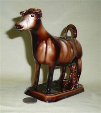 Tall, thin faced Rockingham glaze cow creamer