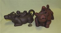 Two Chinese clay water buffalo teapots with boys on lids
