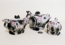 Small grey cow teaset with heads on handle