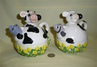 Two similar tea for one cow teapots with cups
