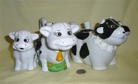 Three thick ceramic cow teapots with cold paint